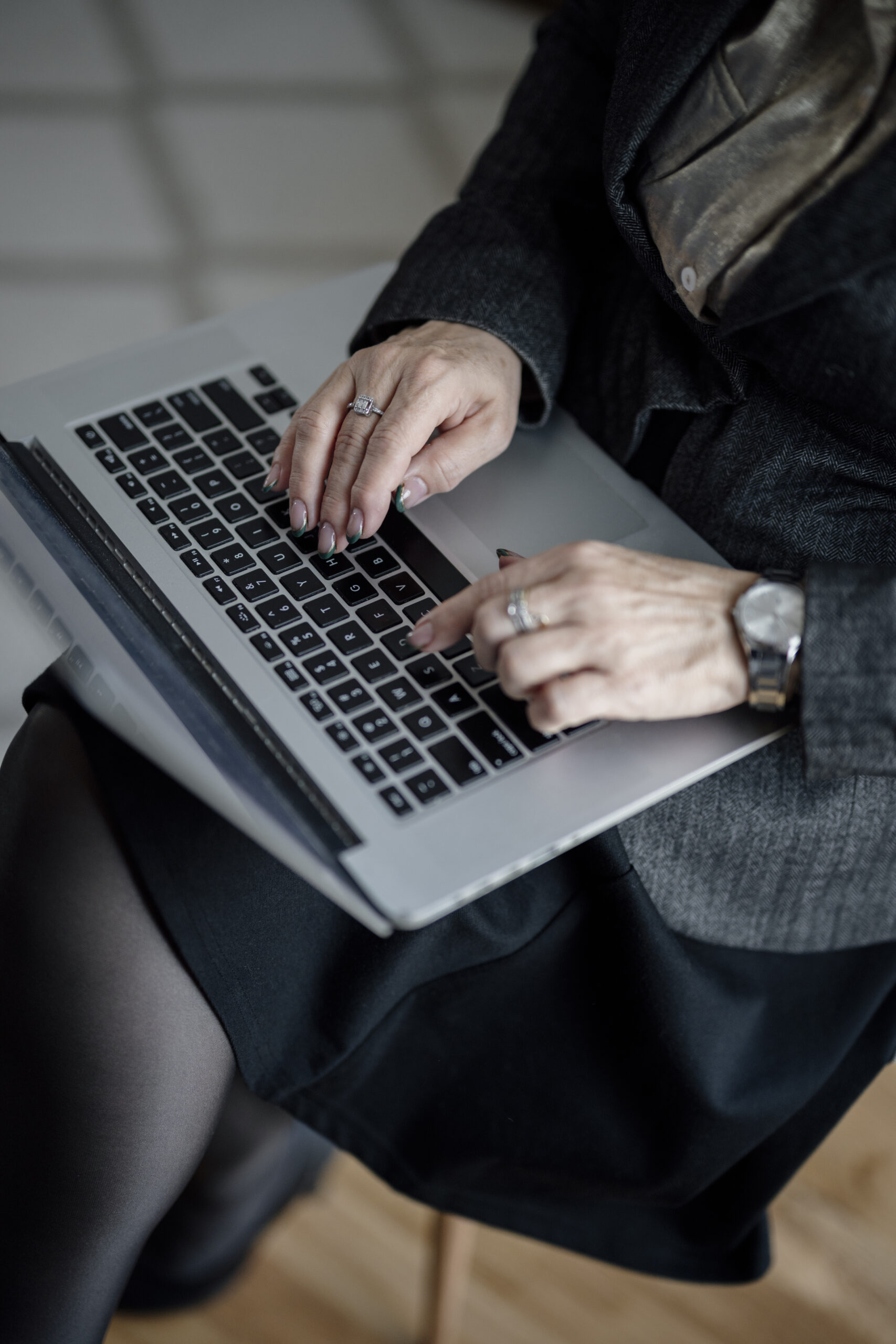 Hands typing on a laptop in a modern office setting